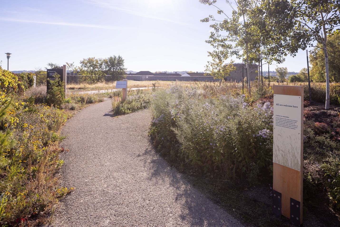 A path with a sign and plants

AI-generated content may be incorrect.