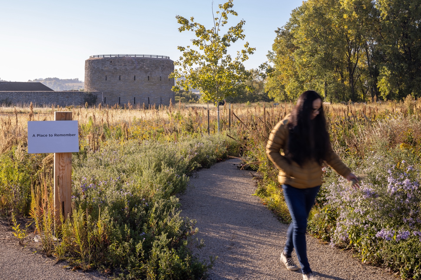 A person walking on a path with a sign

AI-generated content may be incorrect.